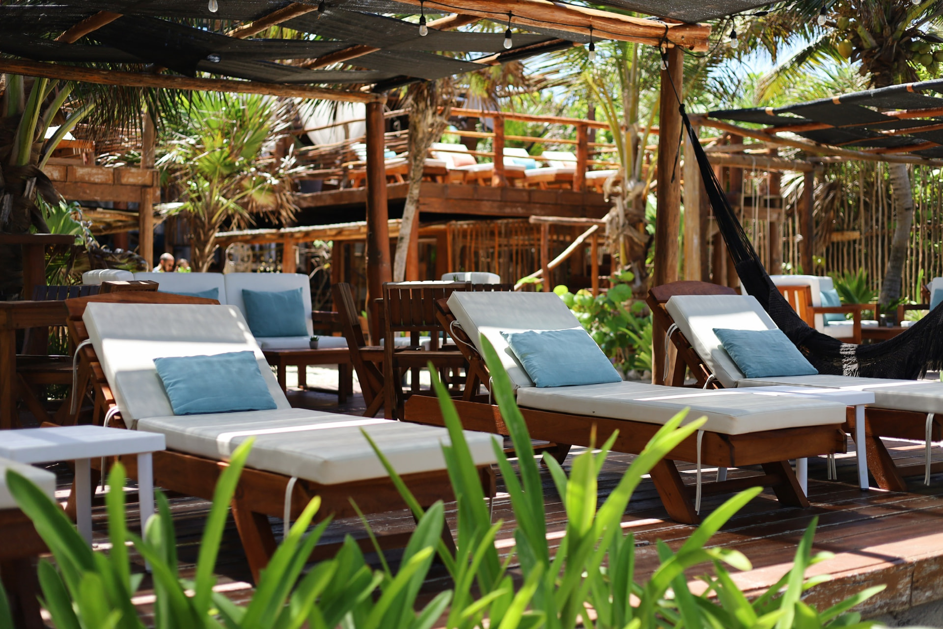 White lounge chairs with blue pillows on the beach at Hayhu